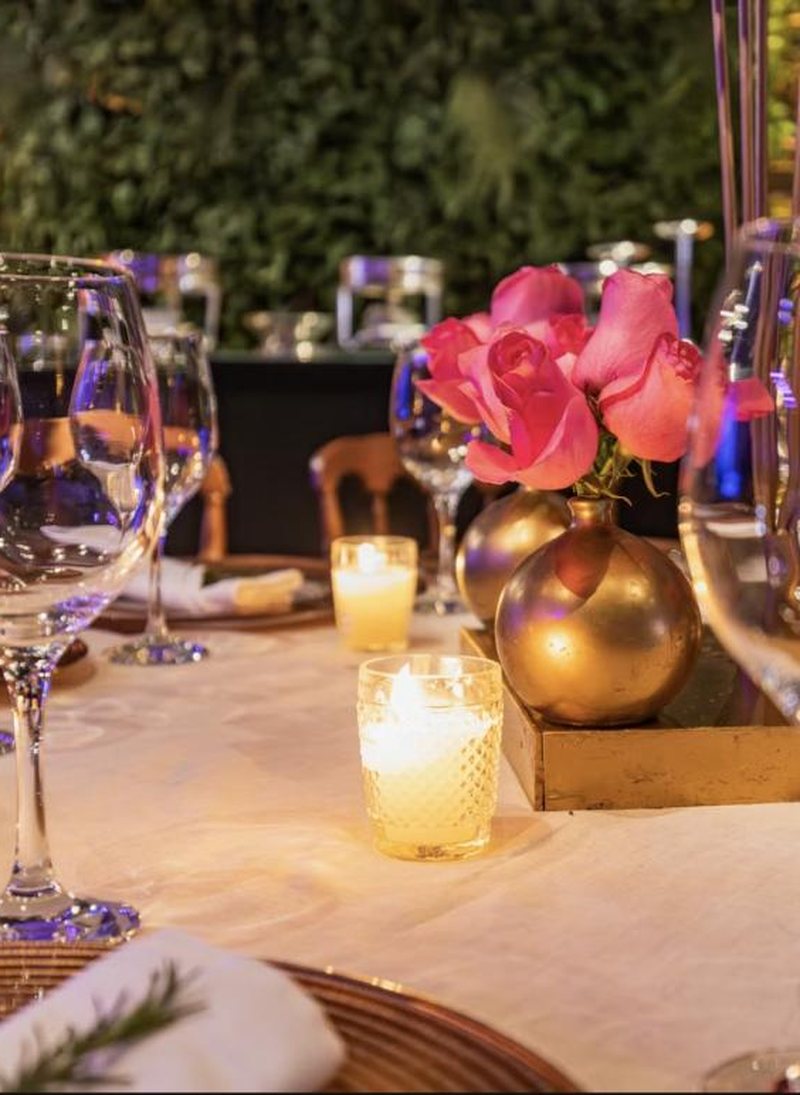 Candlelit wedding tablescape with gold vases and glassware
